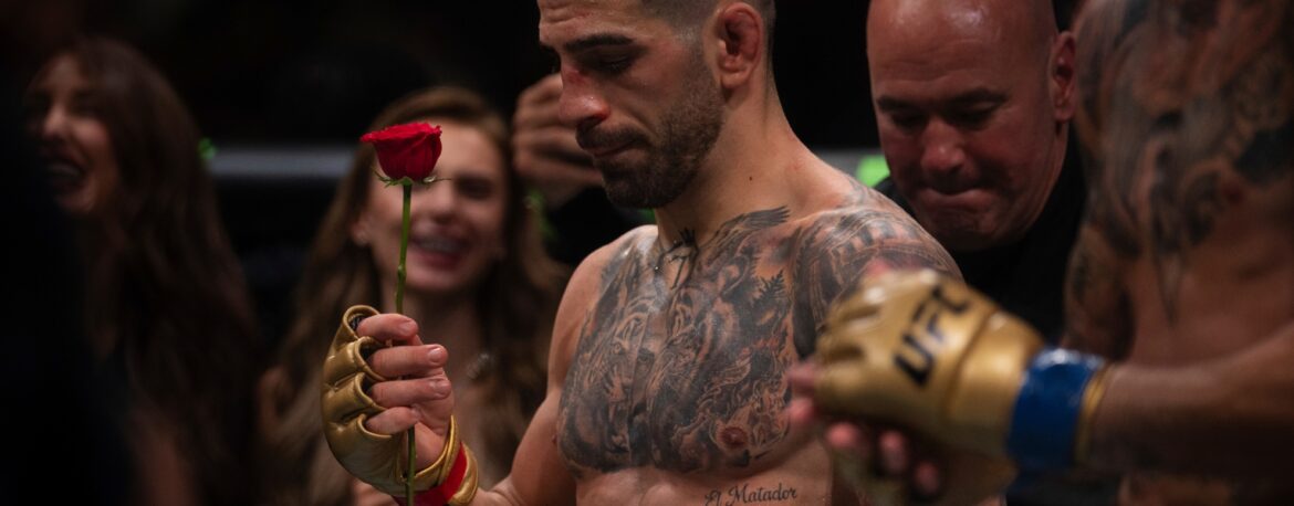 Ilia Topuria posando de forma profesional y elegante en un evento oficial de la UFC.