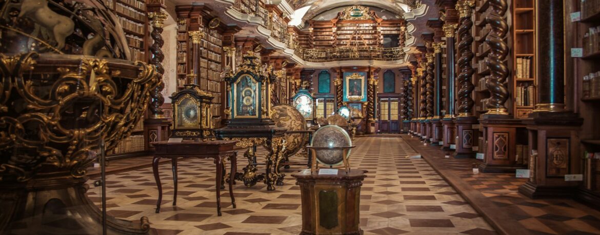 Sala barroca de una biblioteca histórica de Praga con estanterías de libros antiguos y globos terráqueos