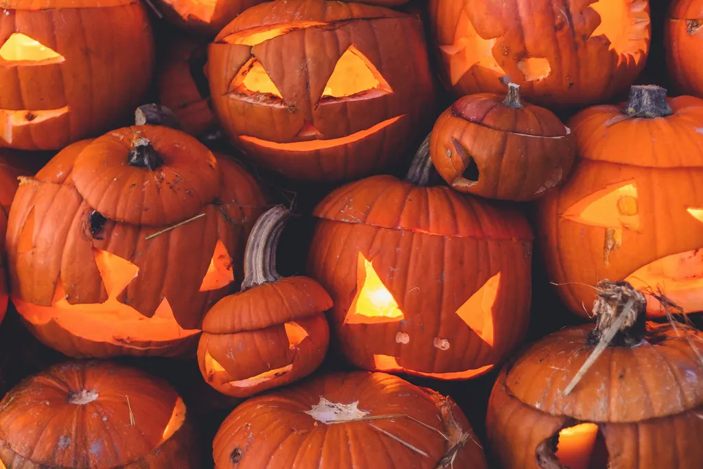 Montón de calabazas con caras talladas apiladas