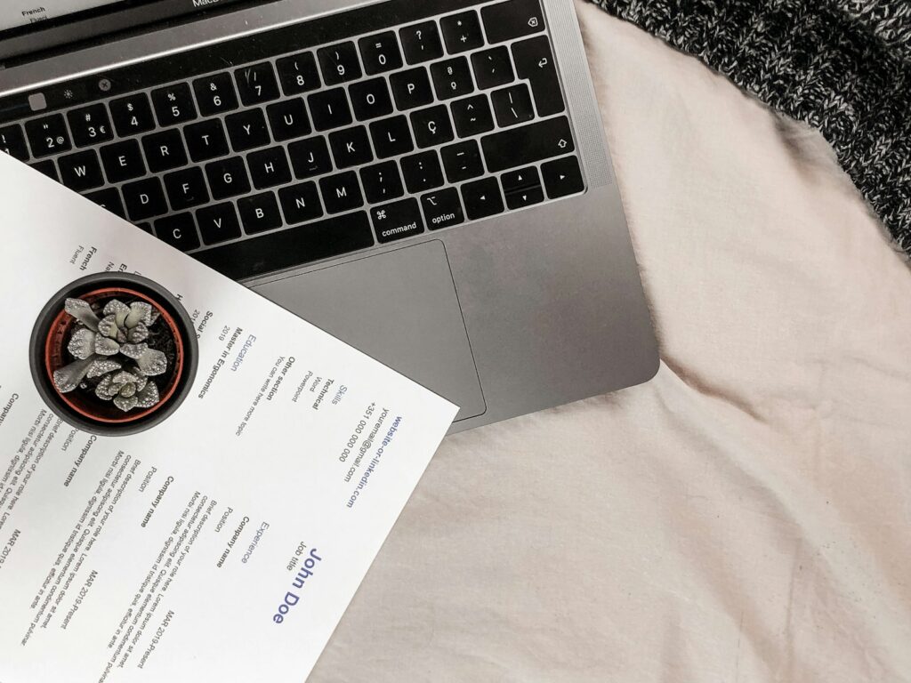 Currículum impreso sobre el teclado de un portátil