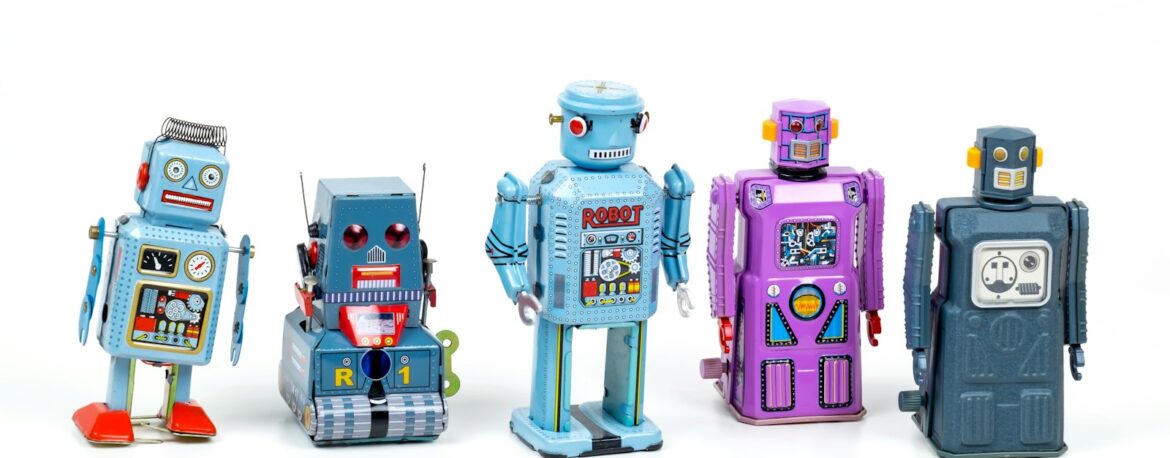 Fila de robots de juguete de hojalata de colores azul y morado sobre un fondo blanco