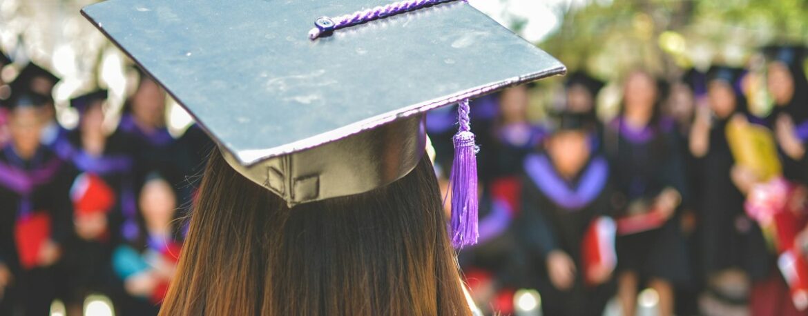 Graduada de espaldas con toga y birrete durante una ceremonia