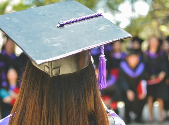 Graduada de espaldas con toga y birrete durante una ceremonia
