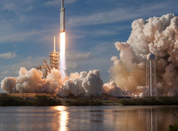 Lanzamiento de un cohete Falcon Heavy con una gran nube de humo junto al agua
