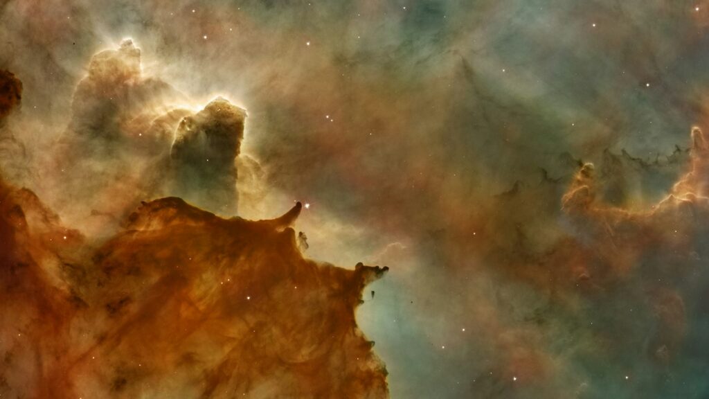 Nebulosa de gas y polvo en tonos naranjas y azules fotografiada por un telescopio espacial
