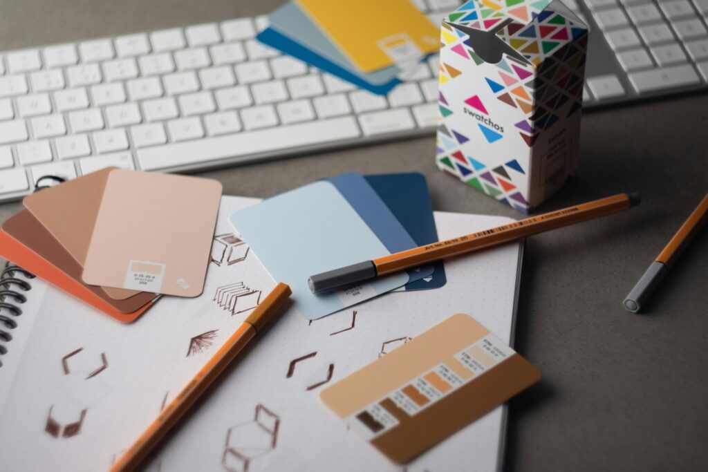 Escritorio con teclado, lápices y muestras de color de un proyecto de diseño