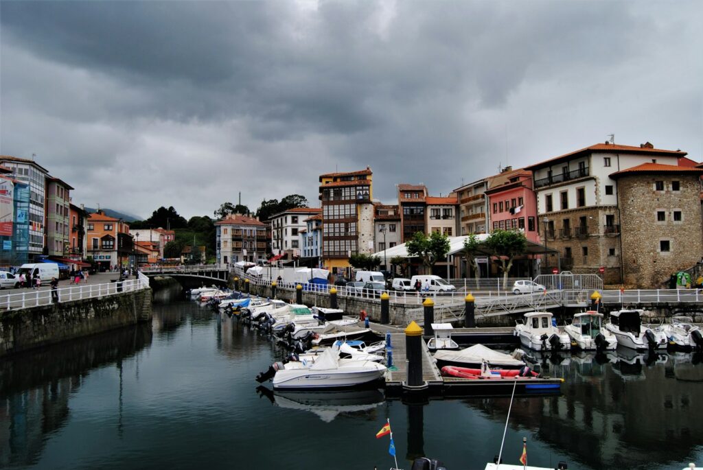 Barcos amarrados en un pequeño puerto pesquero del Cantábrico bajo un cielo nublado