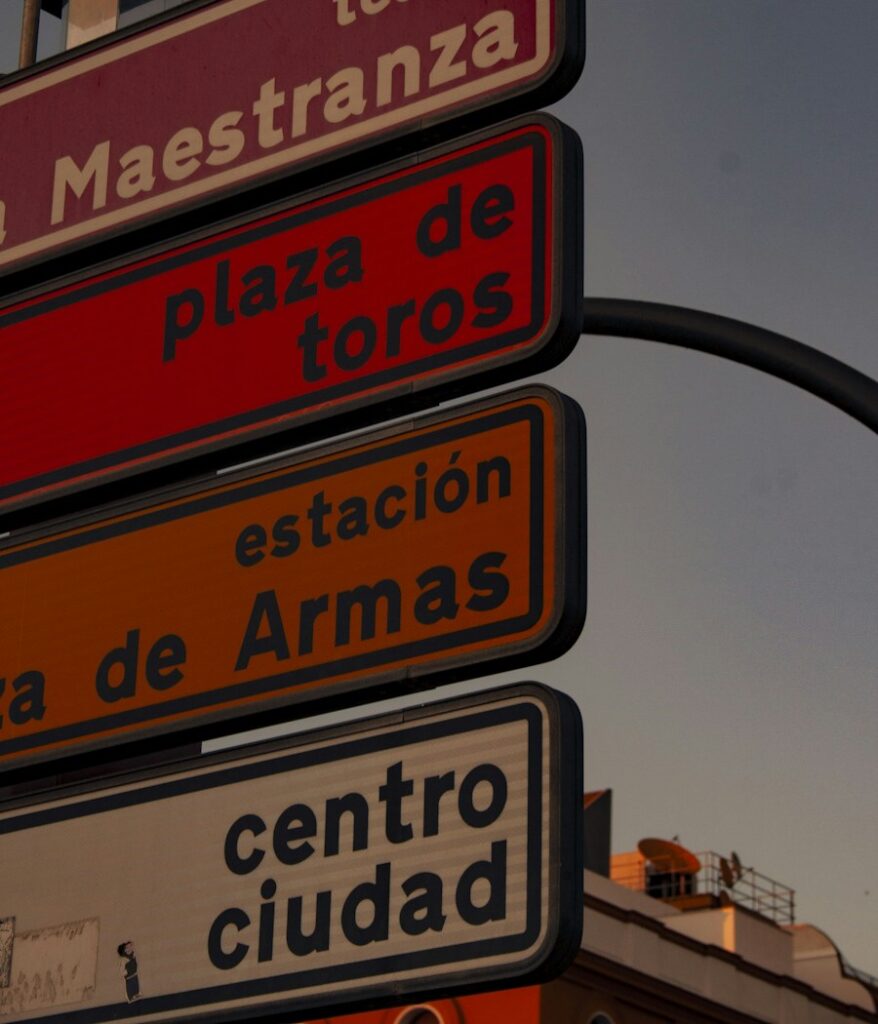 Señales de dirección en Sevilla que indican el Teatro de la Maestranza, la plaza de toros, la estación y el centro de la ciudad
